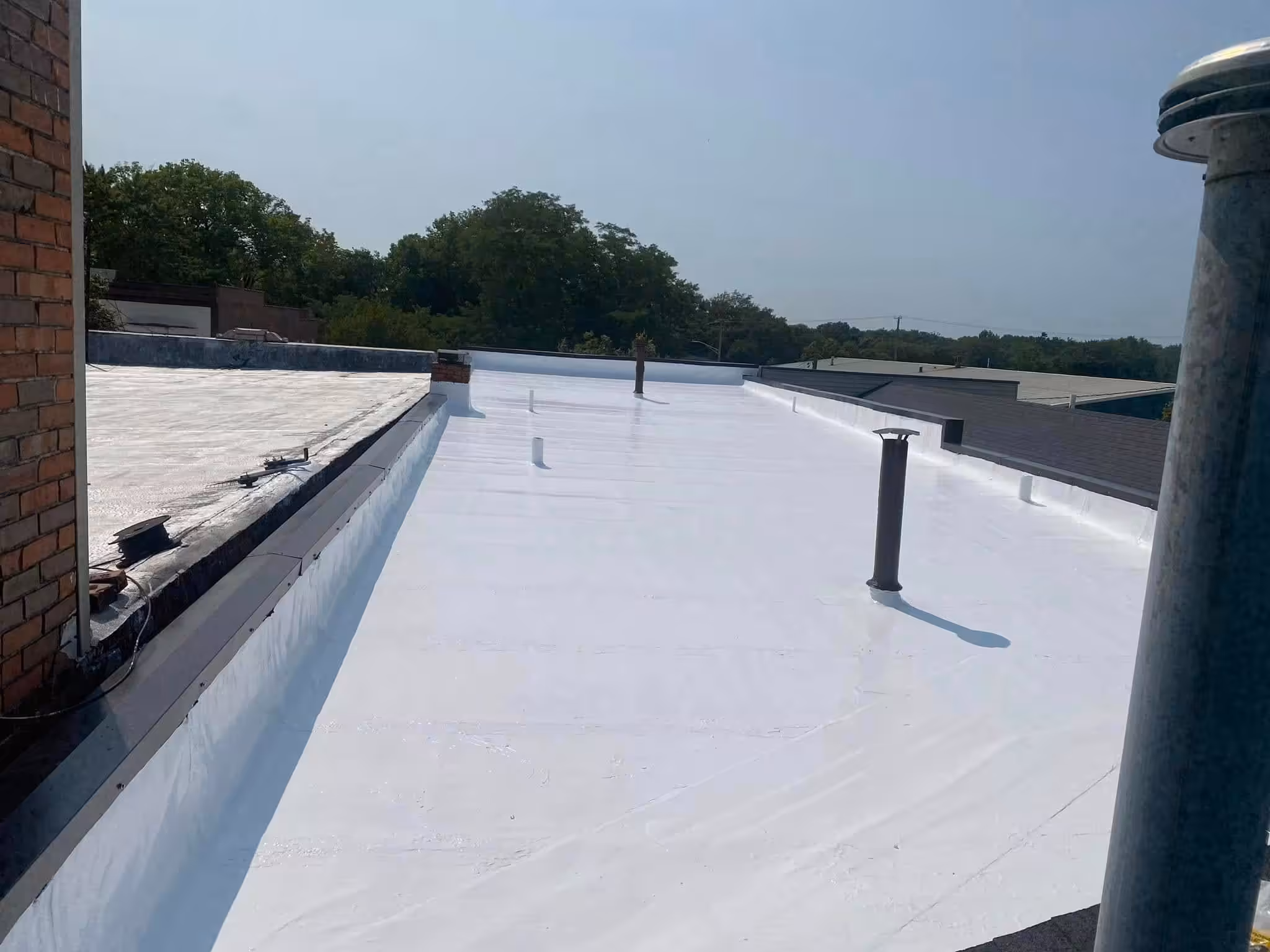 White flat commercial roof in sunny weather.